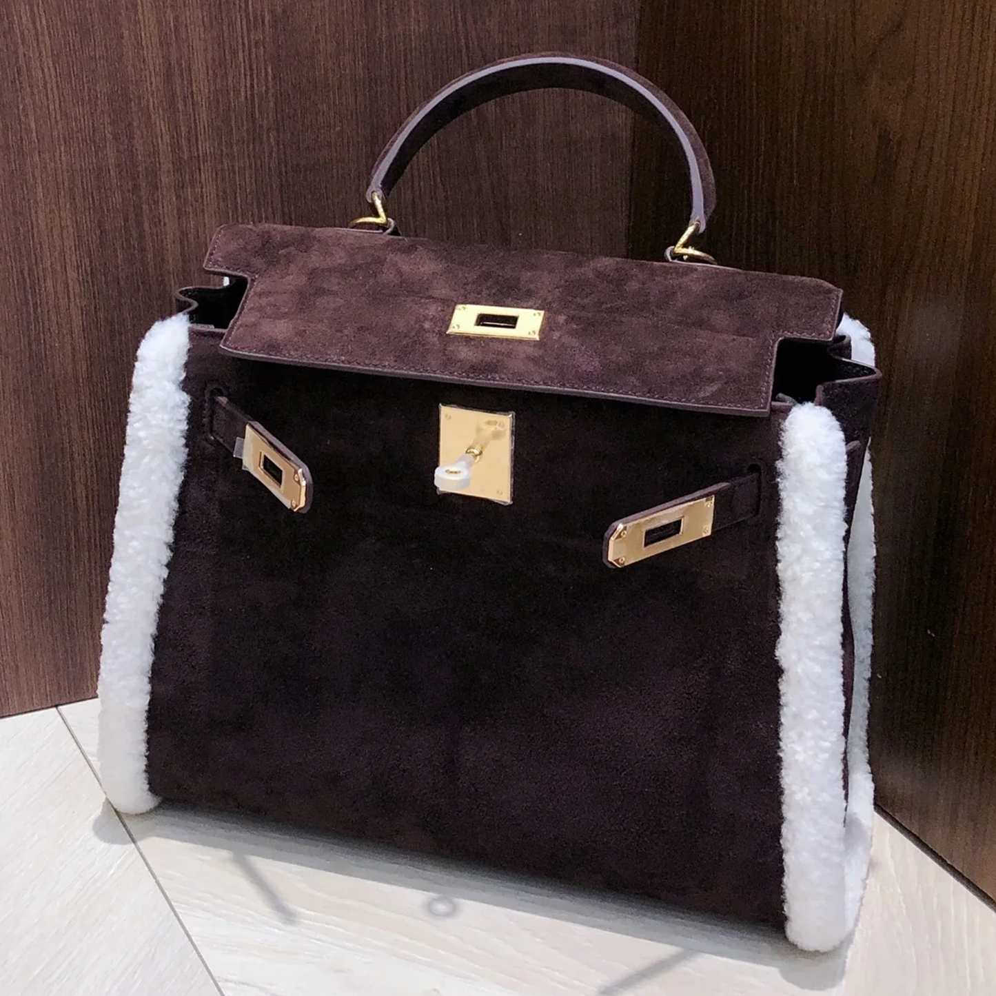 Dark Chocolate Suede Structured Top Handle Bag With White Fluffy Side Trim, Polished Golden Twist Hardware And Spacious Zipper-Lined Interior