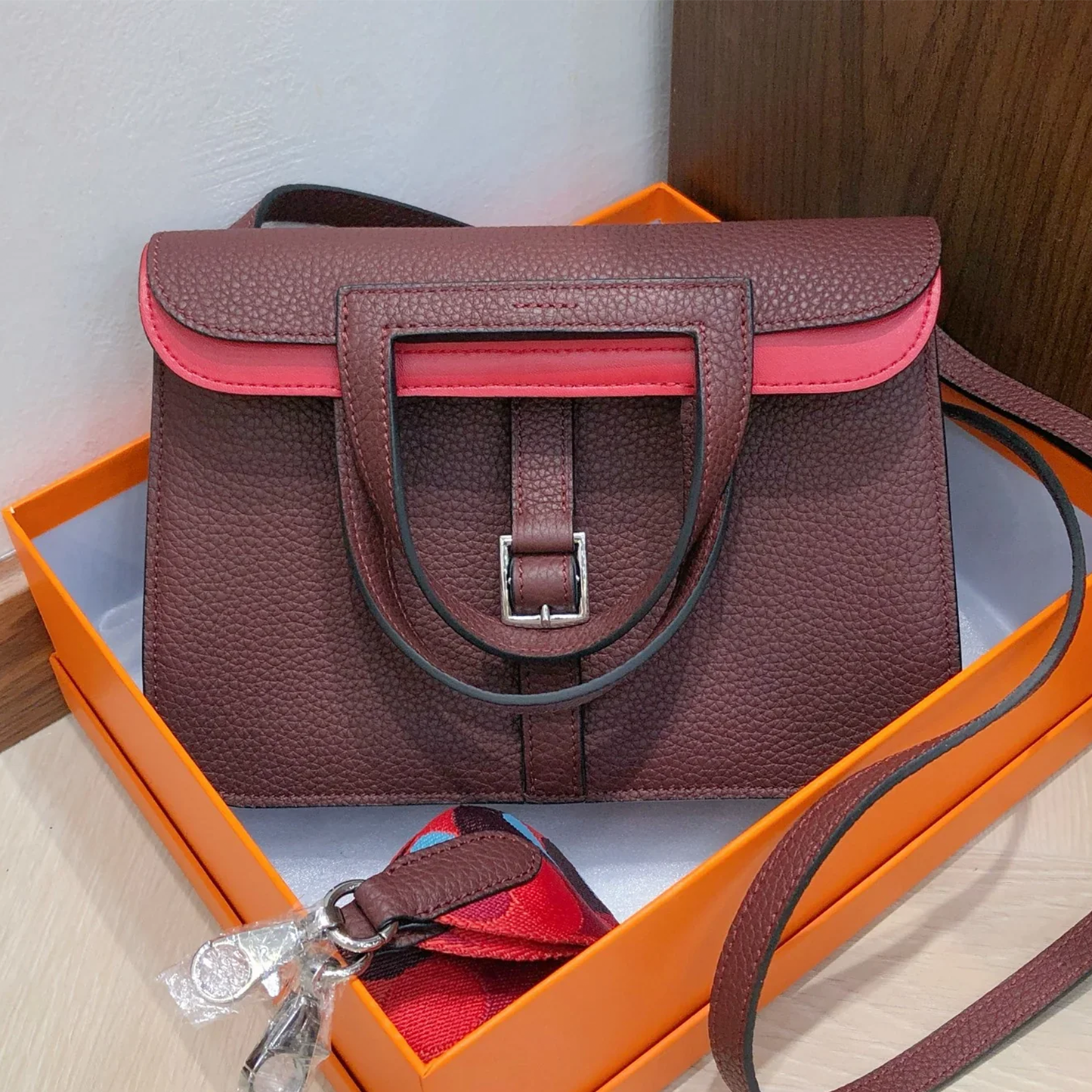 Dual-Tone Burgundy Red Trapezoidal Flap Bag With Integrated Loop Handle, Metallic Buckle Fastener And Slim Matching Shoulder Strap